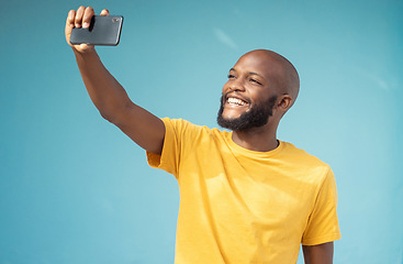 Image showing Black man, happy or selfie on blue background, isolated mock up or wall mockup for social media app or vlogging. Smile, blogger or influencer on tech photography for live streaming or profile picture