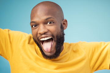 Image showing Black man, portrait or tongue on blue background, isolated mockup or wall backdrop mock up for comic, silly or emoji expression. Happy, funny face or goofy student with fashion, trend or cool clothes