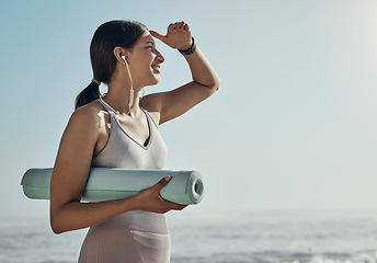 Image showing Fitness, peace and yoga mat by woman at the beach for exercise, balance and cardio on blue sky background. Meditation, training and girl relax at the ocean for wellness, peace and zen at the sea