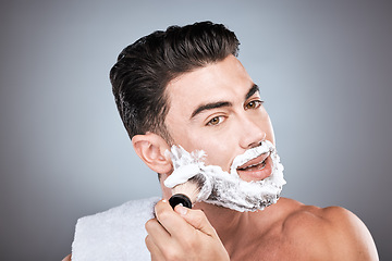 Image showing Shaving cream, face and man with brush in studio isolated on a gray background for hair removal. Beard care portrait, grooming and male model with facial product, foam or gel to shave for wellness.