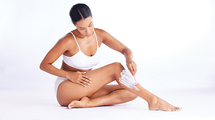 Image showing Skincare, legs and shaving, woman in studio sitting with hand on leg and razor for hair removal product placement. Smooth shave, skin and beauty, body care mockup, girl isolated on white background.