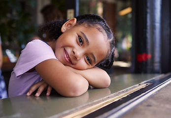 Image showing Portrait, cute and adorable girl at a restaurant, cafe and coffee shop with a smile and happy waiting. Kid, child and young person sitting alone in happiness on a weekend in the city or town