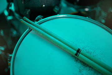 Image showing Top view of sticks on drums instrument in music studio, production or live band in neon green light. Background closeup of drum kit of musician, concert and sound performance to record at talent show
