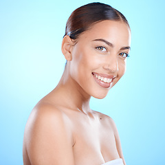 Image showing Skincare, smile and portrait of woman in studio for makeup, wellness or grooming on blue background. Face, beauty and girl skin model relax with luxury, glamour and cosmetic treatment while isolated