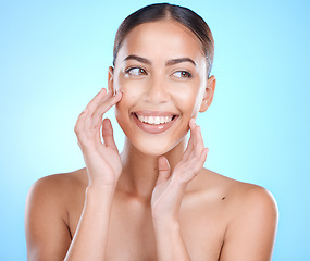 Image showing Makeup, happy and woman with hands on face in studio for skincare, wellness or gentle cleaning on blue background. Face, beauty and girl skin model relax in luxury, cosmetic and facial while isolated