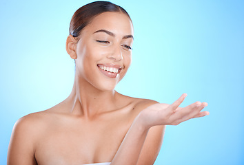 Image showing Skincare beauty, woman and hand with mockup space for natural cosmetics product by blue background. Happy model, skin glow and aesthetic with makeup for cosmetic mock up in studio with excited smile