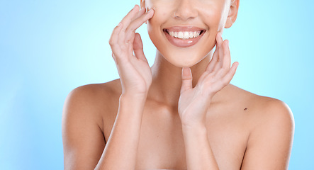 Image showing Hand, face and touching skin with a model woman in studio on a blue background for beauty or skincare. Hands, touch and facial with a young female indoor to promote an antiaging cosmetic product