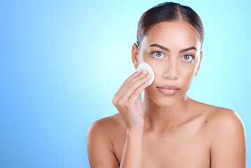 Image showing Portrait, cotton pad and black woman isolated on blue background for face or facial cleaning product promotion. Young model or person for beauty glow, cosmetics wipe and makeup in studio mockup space