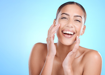 Image showing Portrait, beauty and hands of woman on face in studio for makeup, wellness or gentle cleaning on blue background. Face, skincare and girl skin model relax in luxury, facial or cosmetic while isolated