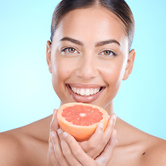 Image showing Portrait, skincare and woman with grapefruit in studio for cosmetics, wellness and treatment on blue background. Face, skin and girl model with fruit, product and luxury cleaning, grooming or hygiene