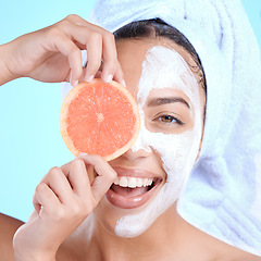 Image showing Portrait, skincare and woman with grapefruit mask in studio for beauty, hair and cosmetics on blue background, Face, facial and girl model relax with fruit, luxury and product, wellness or isolated