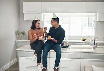 Image showing Cake, birthday and couple in a kitchen for celebration, happy and bonding in their home, smile and laughing. Party, people and man with woman on a counter for eating, fun and celebrating in Japan