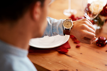 Image showing Man checking watch, time on date at dinner table and waiting for person at a restaurant reservation. Impatient guy alone at coffee shop, stress of modern dating and closeup of looking at wristwatch