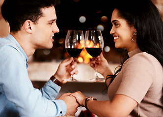 Image showing Date night, wine and fire with couple holding hands at restaurant with love and care. Anniversary celebration, valentines day and happiness of young people together with alcohol in glass with cheers