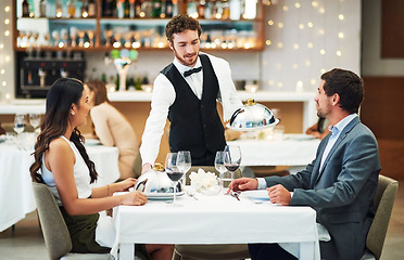 Image showing Happy couple, restaurant server and fine dining food for valentines day date, love or romance in night. Man, woman and waiter with service, party and hospitality for dinner, bonding and celebration