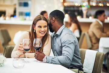 Image showing Restaurant date, interracial couple secret and wine celebration of a man at a dinner table. Anniversary happy, valentines day smile and drink at night with love, care and conversation together