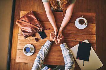 Image showing Above, couple and cafe at table with holding hands, love or conversation for romance together. Man, woman and valentines date in coffee shop for support, bonding or talk for happiness, care and trust