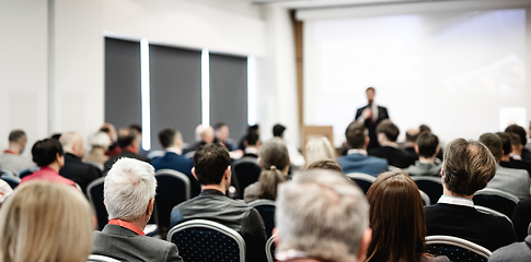 Image showing Speaker giving a talk in conference hall at business event. Rear view of unrecognizable people in audience at the conference hall. Business and entrepreneurship concept.