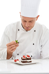 Image showing Chef, presentation and mint on sweet cuisine by culinary cook with chocolate recipe on a plate isolated in white studio background. Cooking, food and man or person making mini cakes in a kitchen