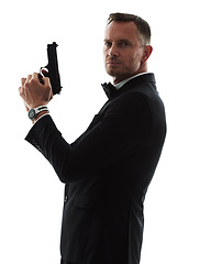 Image showing Spy man, portrait and gun with suit for undercover mission, justice or espionage by white background. Government agent, detective and weapon in studio with designer tuxedo, secret information and job