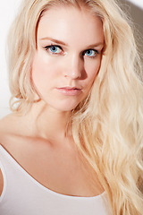 Image showing Portrait, beauty and blue eyes with a model woman in studio on a white background for natural blonde hair. Face, skincare and salon with an attractive young female posing indoor for face treatment