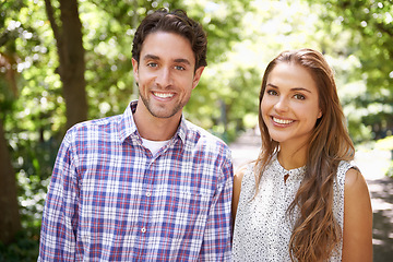 Image showing Park, happy portrait and couple in love on a outdoor date with happiness in nature. Sunshine, vacation and young fun with a smile in summer on holiday feeling relax in sun with blurred background