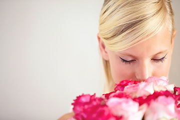 Image showing Smelling, floral and woman with flowers as a gift isolated on a grey studio background. Surprise, romantic and girl with a bouquet of roses for valentines day on a backdrop with mockup space