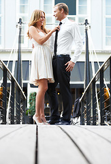 Image showing Romance, embrace and couple on a date in the city with love, happiness and classy in France. Happy, celebration and woman helping a man with a tie while on a bridge during valentines day in town