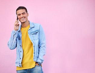 Image showing Phone call, happy and portrait of a man in a studio with a casual, trendy and stylish outfit. Happy, smile and male model on mobile conversation with cellphone by a pink background with mockup space.