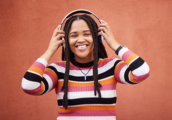 Image showing Wall, portrait and black woman with headphones, smile and carefree with music, streaming and joyful. Face, Jamaican and female with headset for audio, sounds and chilling with happiness and relax