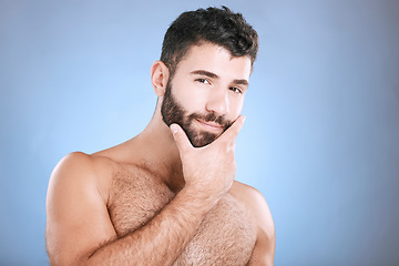 Image showing Skincare, portrait of man and hand on beard, confidence and face cleaning treatment isolated on blue background. Facial hygiene, male model grooming shave and health, wellness and skin care in studio