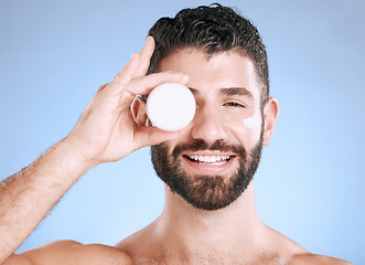 Image showing Cream, skincare jar and man for face, body and happy cosmetics in studio blue background. Facial lotion, male portrait and product for beauty, container and aesthetic for healthy glow, shine or smile