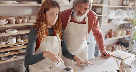 Image showing Art teacher, pottery and senior man in a class, learning tips in art class. Young woman teaching old man to roll clay, sculpture and giving instruction in studio to learn new skill in retirement