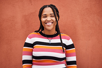 Image showing Portrait, fashion and braids with a black woman on an orange background outdoor for style or empowerment. Style, wellness and profile picture with an african american person posing against a wall