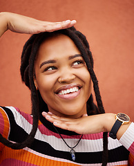 Image showing Pose, happy and woman thinking with hands isolated on a brown studio background. Idea, frame and young girl smiling with happiness, thoughtful and playful while posing on a backdrop for fashion