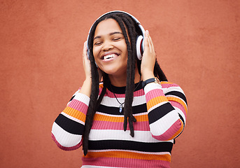 Image showing Wall, black woman and headphones for happiness, radio and freedom with girl chilling, calm and relax on studio backdrop. Jamaican, happy female and lady with headset for music, streaming and podcast