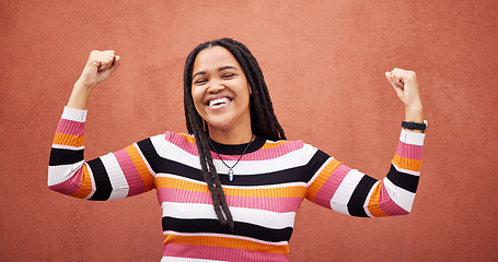 Image showing Celebration, happy and woman by a wall in the city on a walk while on a holiday or weekend trip. Happiness, smile and African female celebrating with freedom in urban town on a vacation or adventure.