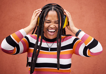 Image showing Black woman, music headphones and happiness by wall in city for walk, adventure and comedy album. Young gen z girl, audio streaming and listen to comic podcast on website, radio and happy in metro