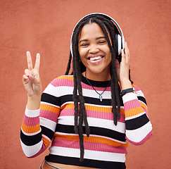 Image showing Portrait, headphones and black woman with peace sign isolated on orange wall for gen z music or mental health. Young person or v hands of youth listening to audio 5g technology or streaming services