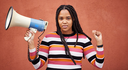 Image showing Protest, megaphone and portrait of a woman by a wall in the city for freedom, equality and human rights. Fist, speaker and African female fighting at a rally for justice, democracy and racism in town