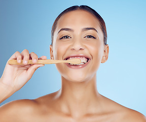 Image showing Teeth, woman and portrait of bamboo toothbrush for dental wellness, healthy cleaning or beauty cosmetics. Happy female, eco wooden brush and toothpaste of mouth, face smile and studio blue background