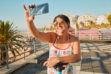 Image showing Vacation, selfie and happy senior woman in retirement riding a scooter on the beach promenade. Happiness, smile and elderly female taking picture while having fun on holiday or weekend trip in Mexico