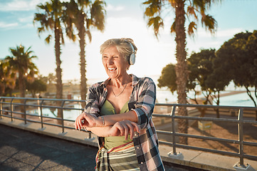 Image showing Happy old woman, headphones and music on holiday at tropical island resort with smile and palm trees. Summer, happiness and funky grandma streaming 5g radio service on retirement vacation in Hawaii.