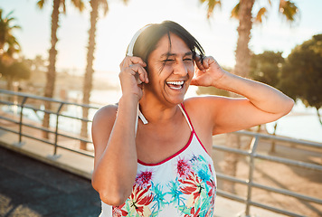 Image showing Headphones, senior woman and laughing of a elderly person in Miami happy from summer holiday. Beach, music listening and web audio streaming of a old female with happiness on vacation in retirement