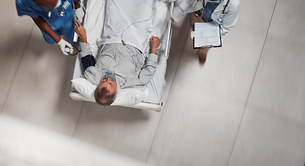 Image showing Hospital bed, icu healthcare and doctor with patient in a medical clinic from above. Emergency, wellness team and man going into surgery for injury, health care check or wellness consultation