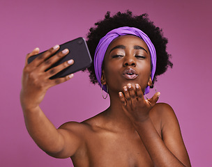 Image showing Selfie, love and black woman blowing a kiss isolated on a purple background in studio. Care, beauty and African girl with a photo, video call or communication on a mobile while showing affection