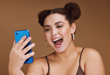 Image showing Phone, selfie and face of woman with smile on brown background for wellness, fashion and makeup. Wow, video call and happy girl influencer on smartphone for social media, internet and online post