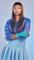 Image showing Arms crossed, fashion and portrait of a trendy woman isolated on a blue studio background. Confident, cool and edgy model standing with fashionable clothes, stylish and elegant on a backdrop