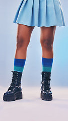 Image showing Boots, gen z fashion and legs of a young women in a studio with rock and pastel punk aesthetic. Isolated, blue background and colorful clothes of a person with creative cyberpunk and unique clothing