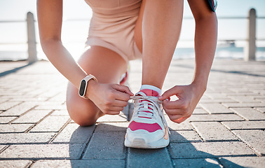 Image showing Closeup, fitness and woman tie shoes, training and exercise for wellness, health and performance. Zoom, female athlete and lady with tying shoes, ready for marathon and run for cardio and energy